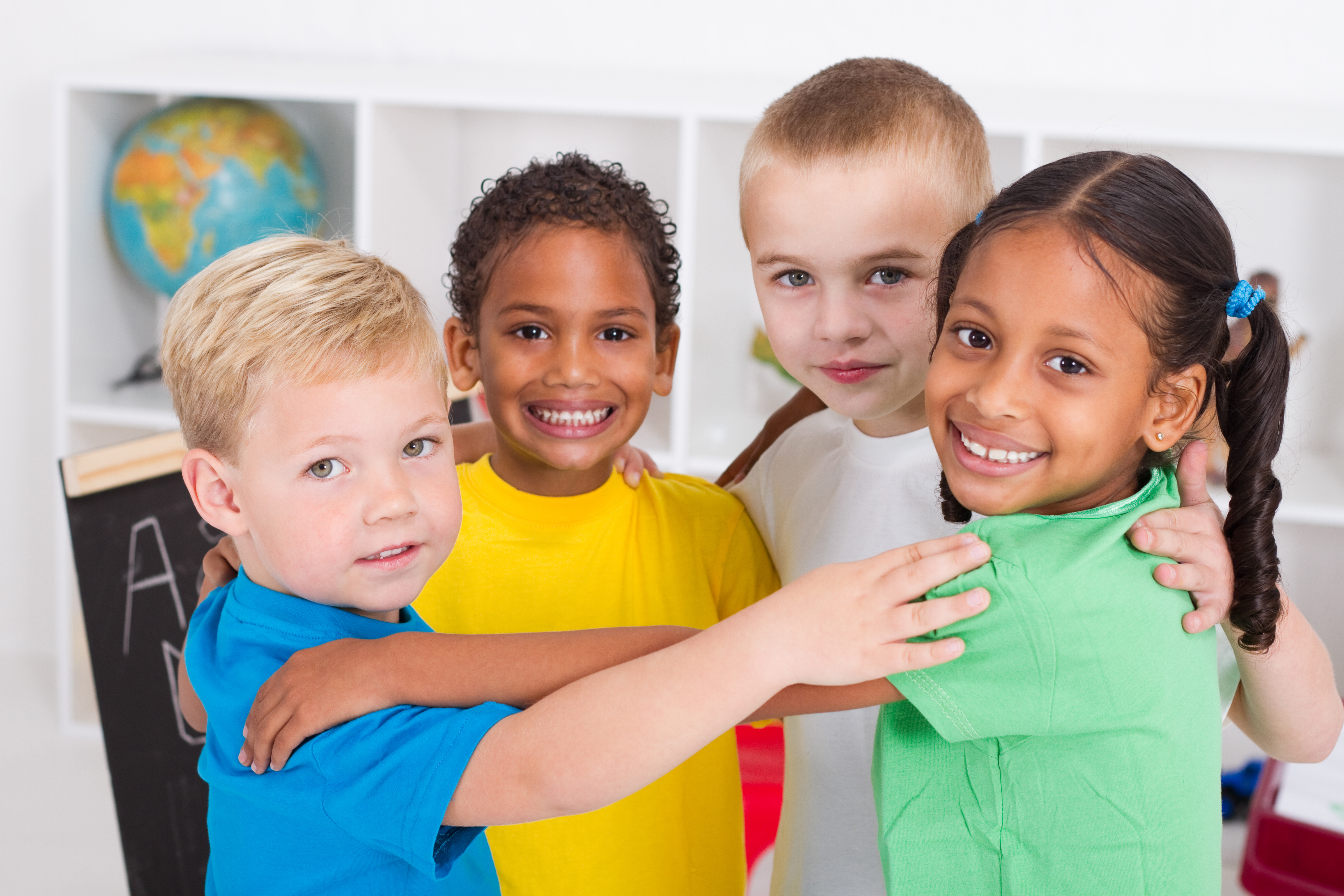 Young group of diverse children hugging and smiling